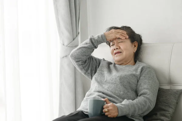 Asiática senior mujer having headache en casa, salud cuidado concepto . —  Fotos de Stock