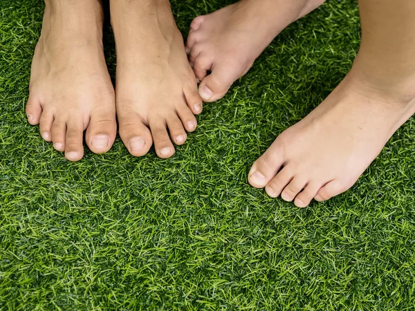 Pieds sur fond d'herbe verte . — Photo