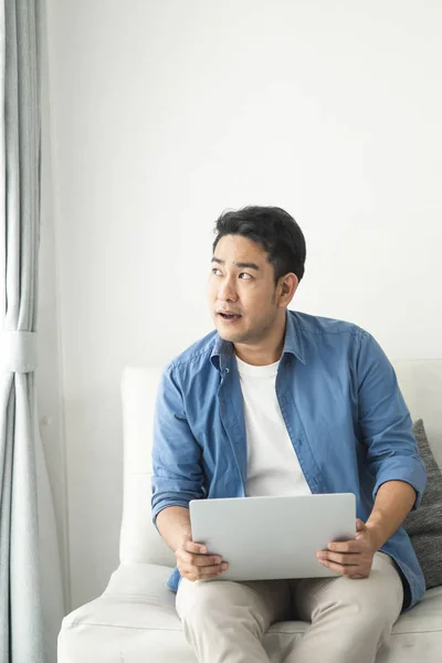 Hangsúlyozta, ázsiai ember használ laptopot otthon, életmód koncepció — Stock Fotó