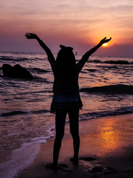 Mädchen hebt die Hände mit Sonnenaufgang am Strand Hintergrund. — Stockfoto