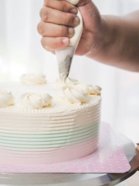 Bir hamur işi çanta kullanarak kremalı kek Tepesi pudra,