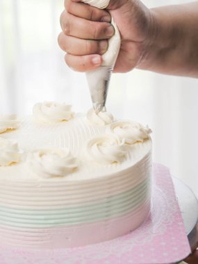 Bir hamur işi çanta kullanarak kremalı kek Tepesi pudra,