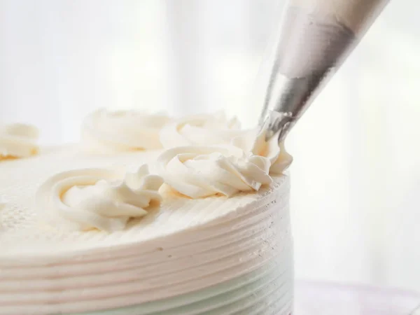 Cukiernik polewa ciastek z kremem za pomocą worka ciasta, — Zdjęcie stockowe