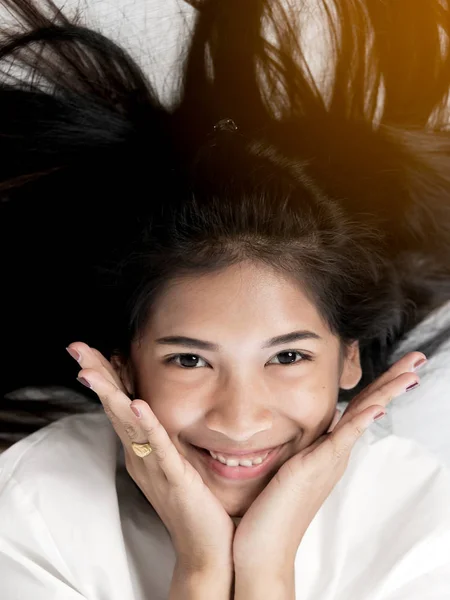 Asian teenager girl lying on the floor and looking at camera, to — Stock Photo, Image