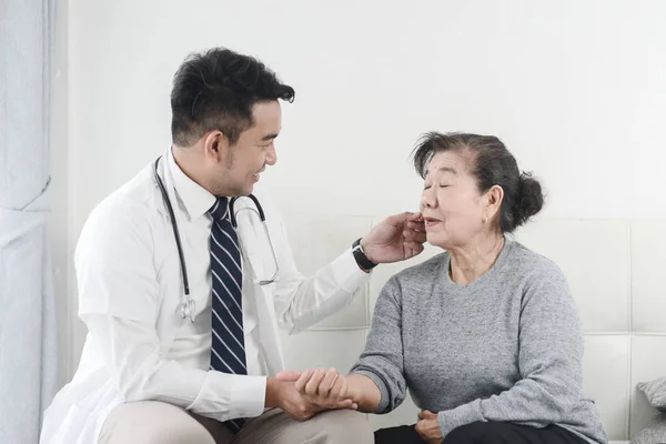 Asiatische Arzt Überprüfung bis seine geduldige alte Frau in Büro. — Stockfoto