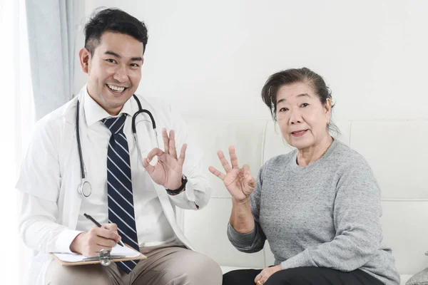 Aziatische arts en senior patiënt met oke handen teken, gezondheid auto — Stockfoto