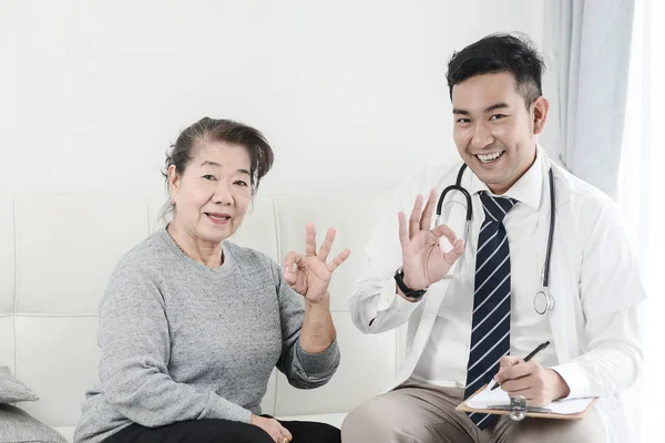 Aziatische arts en senior patiënt met oke handen teken, gezondheid auto — Stockfoto
