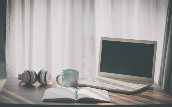 Taza de café con portátil portátil blanco y auriculares en la mesa nea —  Fotos de Stock