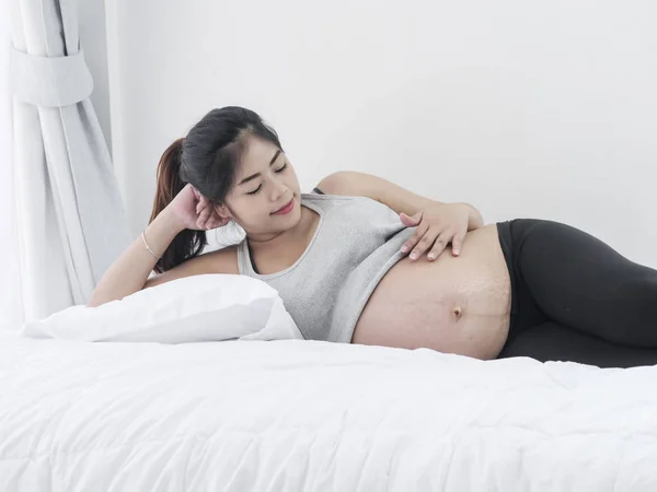 Asiatico incinta donna riposo su letto a casa, lifestyle concept . — Foto Stock