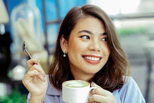 Mujer asiática bebiendo una taza de té verde caliente partido en la cafetería, la vida —  Fotos de Stock