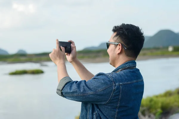 彼のスマートフォンで写真を撮るアジアの観光客、ライフスタイルコンセプト — ストック写真