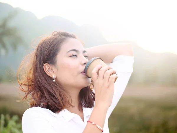 Emotionele Aziatische vrouw drinkng nemen weg koffie kopje met zon LIGH — Stockfoto