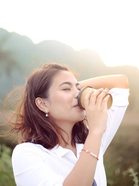 Emocional mujer asiática beber llevar taza de café con sol ligh —  Fotos de Stock