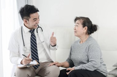 Asyalı doktor ve başparmak ile üst düzey hasta kadar el işareti, healt