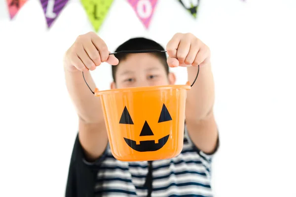 Niño asiático con cubo de calabaza naranja, concepto de Halloween . — Foto de Stock