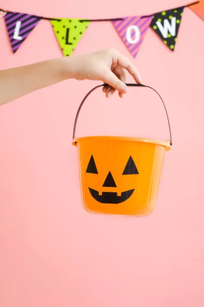 Cubo de plástico de calabaza naranja para niños con respaldo rosa — Foto de Stock