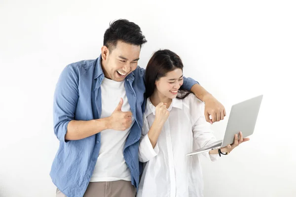 Feliz ásia casal usando laptop contra branco parede estilo de vida co — Fotografia de Stock