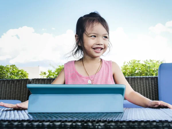 Menina asiática usando tablet na mesa com fundo da natureza . — Fotografia de Stock