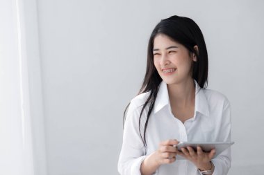 Güzel Asyalı kadın Beyaz gömlekli penceresinde yakınındaki tablet kullanma