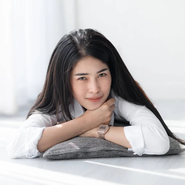 Hermosa mujer asiática en camisa blanca relajándose en el suelo cerca del viento —  Fotos de Stock