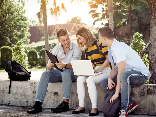 Ευτυχισμένο Πανεπιστήμιο μαθητή χρησιμοποιώντας φορητό υπολογιστή μαζί έξω από το κτίριο — Φωτογραφία Αρχείου