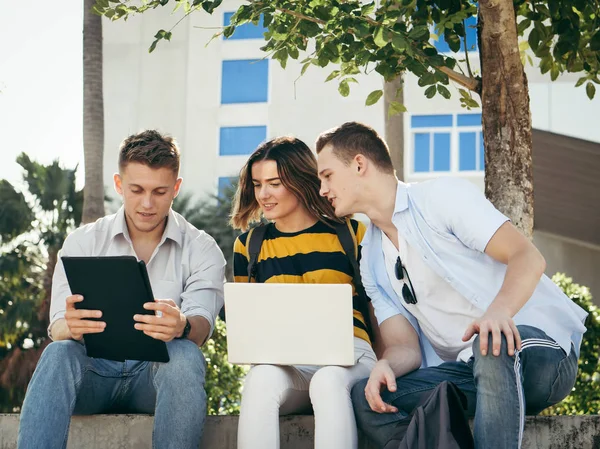 Heureux étudiant universitaire utilisant ordinateur portable ensemble à l'extérieur du bâtiment — Photo