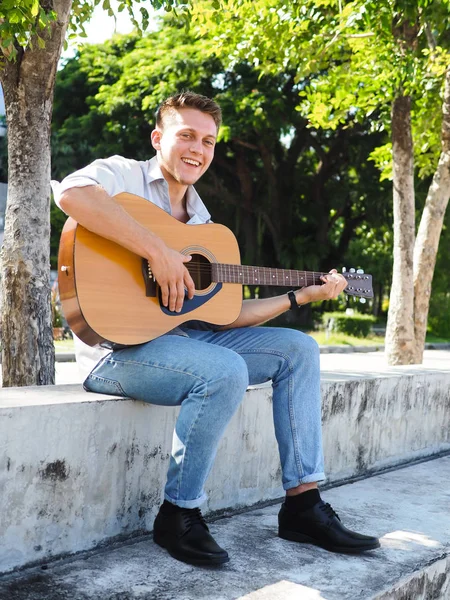 Campus student spelar gitarr utomhus, livsstil Concept. — Stockfoto