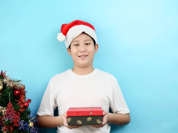 Asiático preadolescente niño sosteniendo rojo caja de regalo con el concepto de Navidad . — Foto de Stock