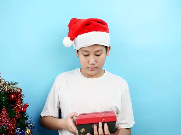 亚洲青春期男孩拿着红色礼品盒与圣诞节的概念. — 图库照片