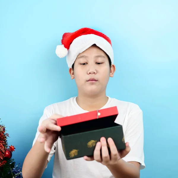 亚洲青春期男孩拿着红色礼品盒与圣诞节的概念. — 图库照片