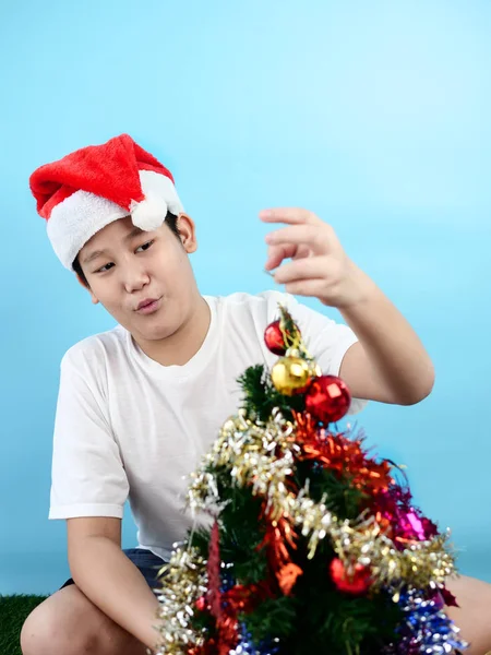 Asiatiskapojke bär röd Santa hatt dekorera julgran, semest — Stockfoto