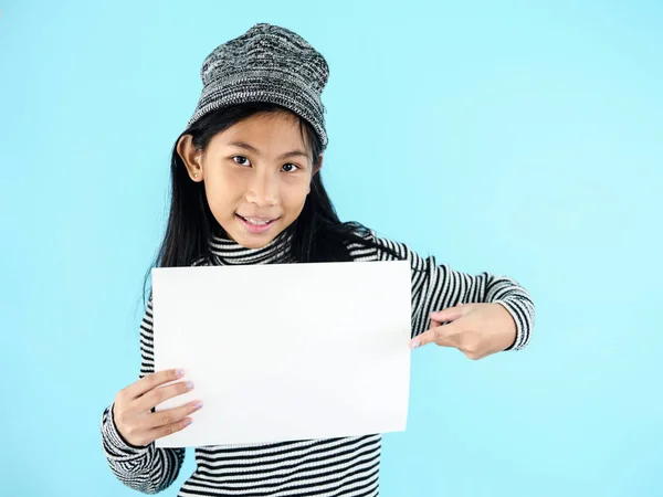 Asiatisk tjej i vinter kostym hålla vitt blankt papper på blå b — Stockfoto