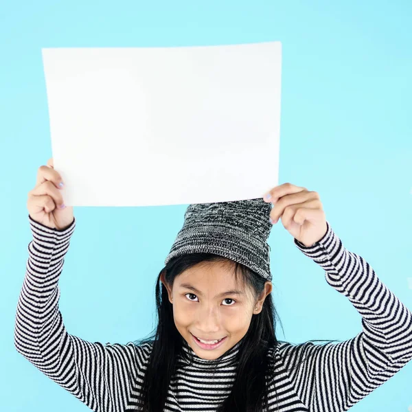 Asiatisches Mädchen im Winterkostüm mit weißem Blanko-Papier auf blauem B — Stockfoto