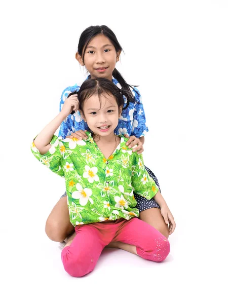 Азіатські дівчата і її сестра обіймаючи разом і дивиться на камеру — стокове фото