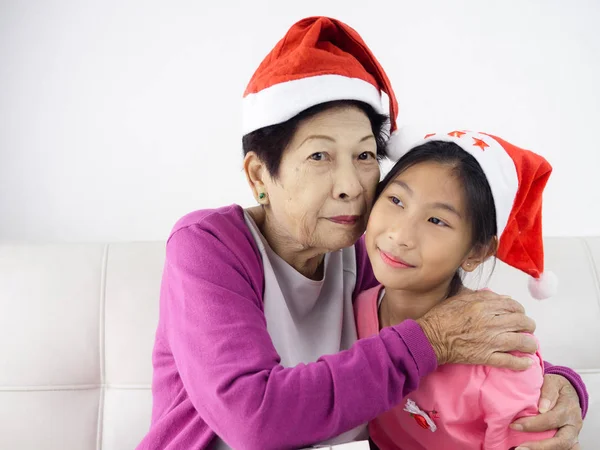 Asian senior woman holding gift box to her grandchild, holiday c