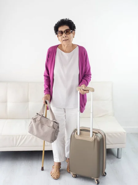 Asiática senior mujer sosteniendo bolso y equipaje, listo para viajar — Foto de Stock