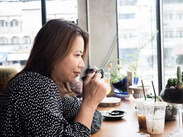 Asiatin entspannt im Café, Lifestylekonzept. — Stockfoto