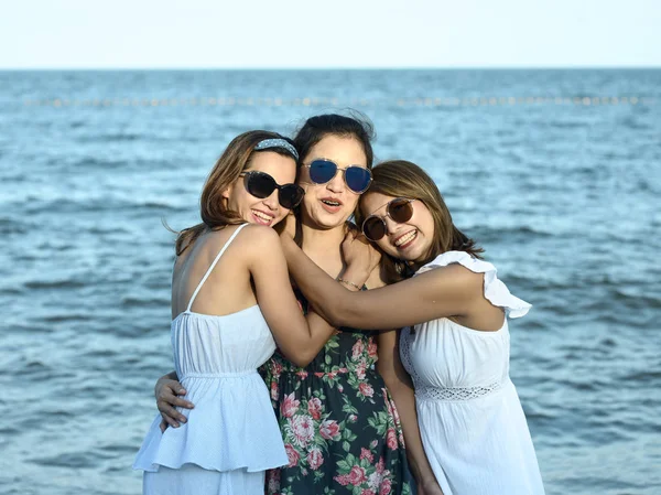 Feliz Asiática mujeres usando vestido largo y de pie en la playa t — Foto de Stock