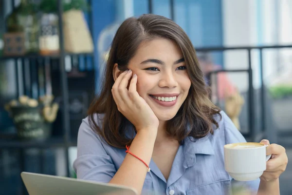 Feliz mujer asiática bebiendo café caliente mientras trabaja en la cafetería, lif — Foto de Stock