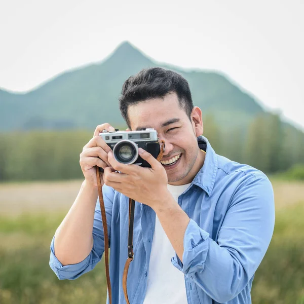 Asiatischer Fotograf mit Vintage-Kamera beim Fotografieren in der Natur — Stockfoto