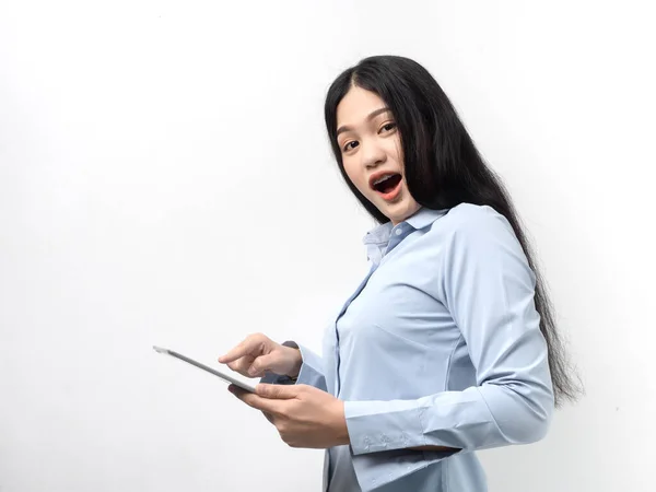 Mujer asiática feliz en camisa azul usando tableta sobre fondo blanco —  Fotos de Stock