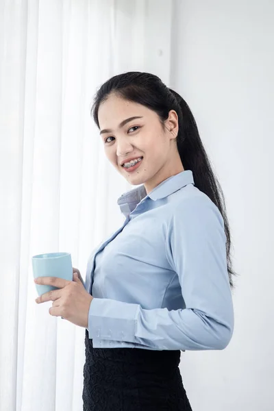 Asiática mujer de negocios beber café cerca de ventana en la mañana , —  Fotos de Stock