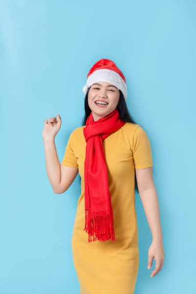 Asian woman in yellow dress wearing red scarf and Santa hat, hol — ストック写真