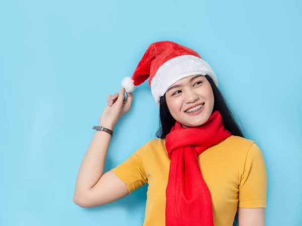 Asian woman in yellow dress wearing red scarf and Santa hat, hol — ストック写真