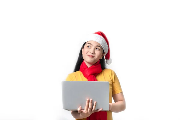 Asian woman with red Santa hat and scarf holding laptop on white — Stock Photo, Image