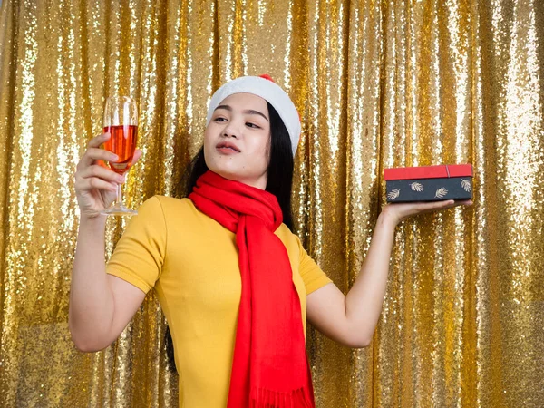 Happy Asian woman with red Santa hat and drinking red wine on go — ストック写真