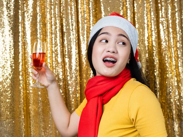 Happy Asian woman with red Santa hat and drinking red wine on go — ストック写真