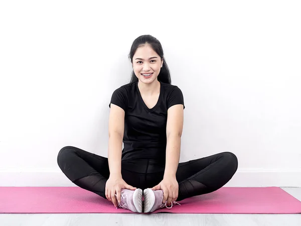 Glücklich asiatische Sportlerin betet auf rosa Yogamatte zu Hause, am lebendigsten — Stockfoto