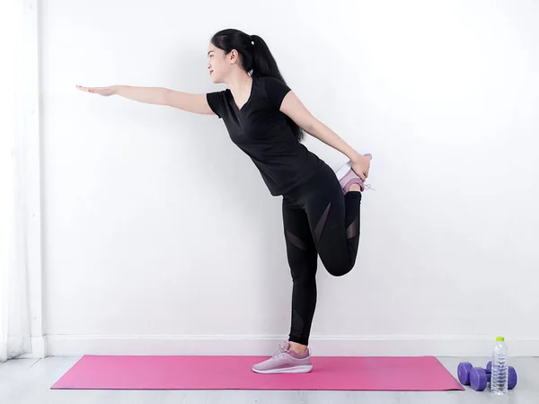 Felice donna sportiva asiatica che fa yoga sul tappeto rosa a casa, stile di vita — Foto Stock