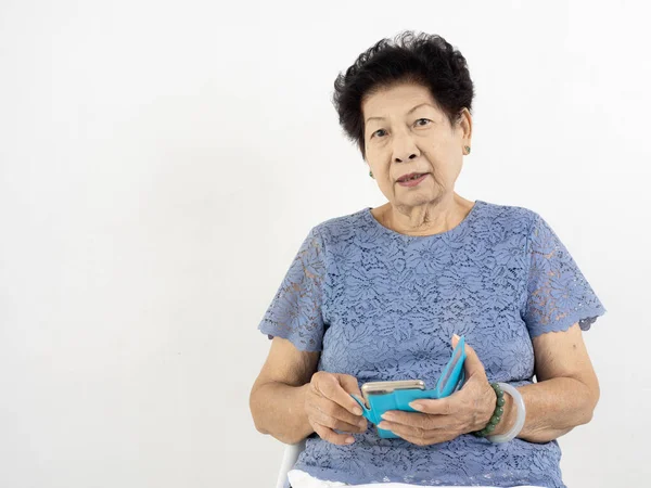 Asiática senior mujer usando inteligente teléfono en casa . —  Fotos de Stock